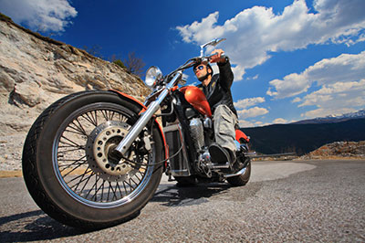 a man riding a motorcycle down a dirt road